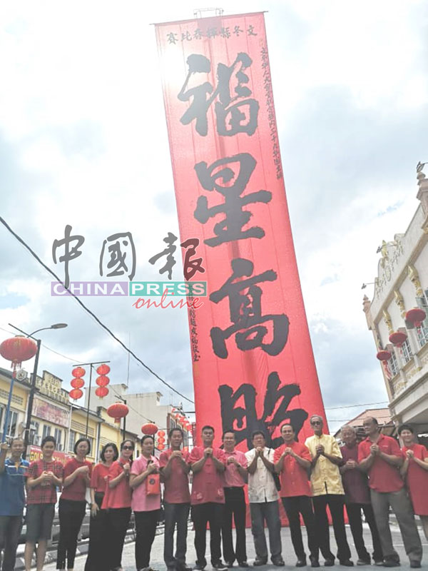 华人大会堂理事和贵宾们在巨大祝福语前祝贺市民。