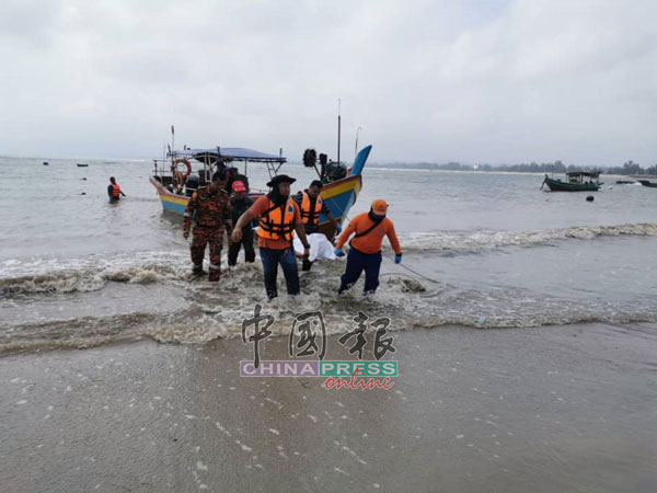 搜救人员将寻获的莫哈末依克旺遗体抬上岸。