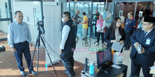 阿米诺胡达（右起）与廖彩彤，巡视设在士乃国际机场入境通道的人体热能探测器设备。