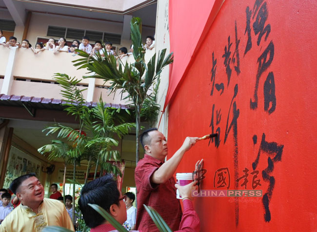 郭佳安（右）为壁画写下落款。