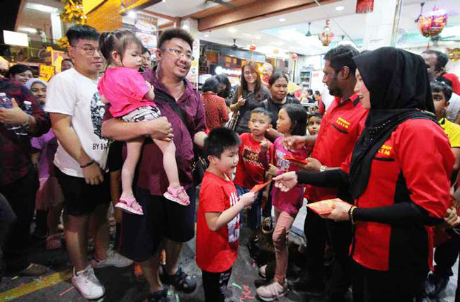 沙林夫妇（右起）依据华人传统，派发红包予孩童。