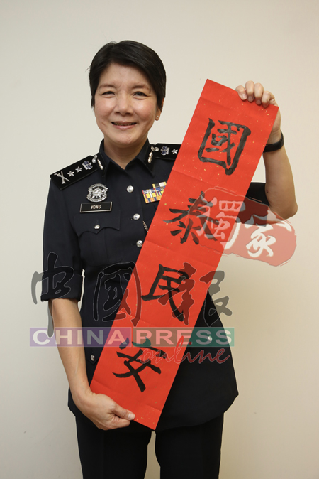 <b>吉隆坡副总警长拿督杨丽珠</b>手持春联，祝新的一年，国泰民安，也祝《中国报》读者新年快乐。