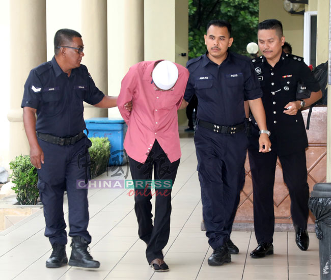 全程低头的赛阿布峇卡（左2）遭警方带往法庭面控。