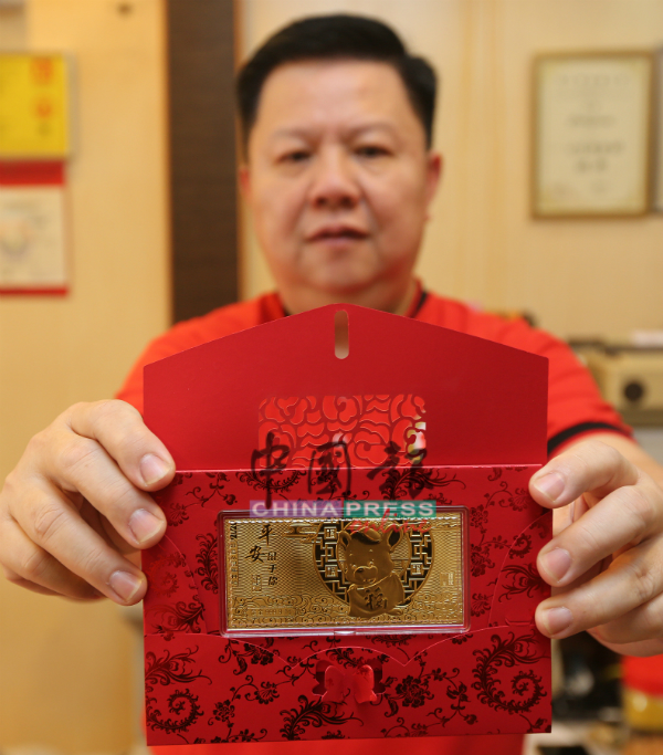 公信隆金铺负责人赖乃能展示金鼠“金钞”，也能作为红包封送礼，凸显礼轻情意重。