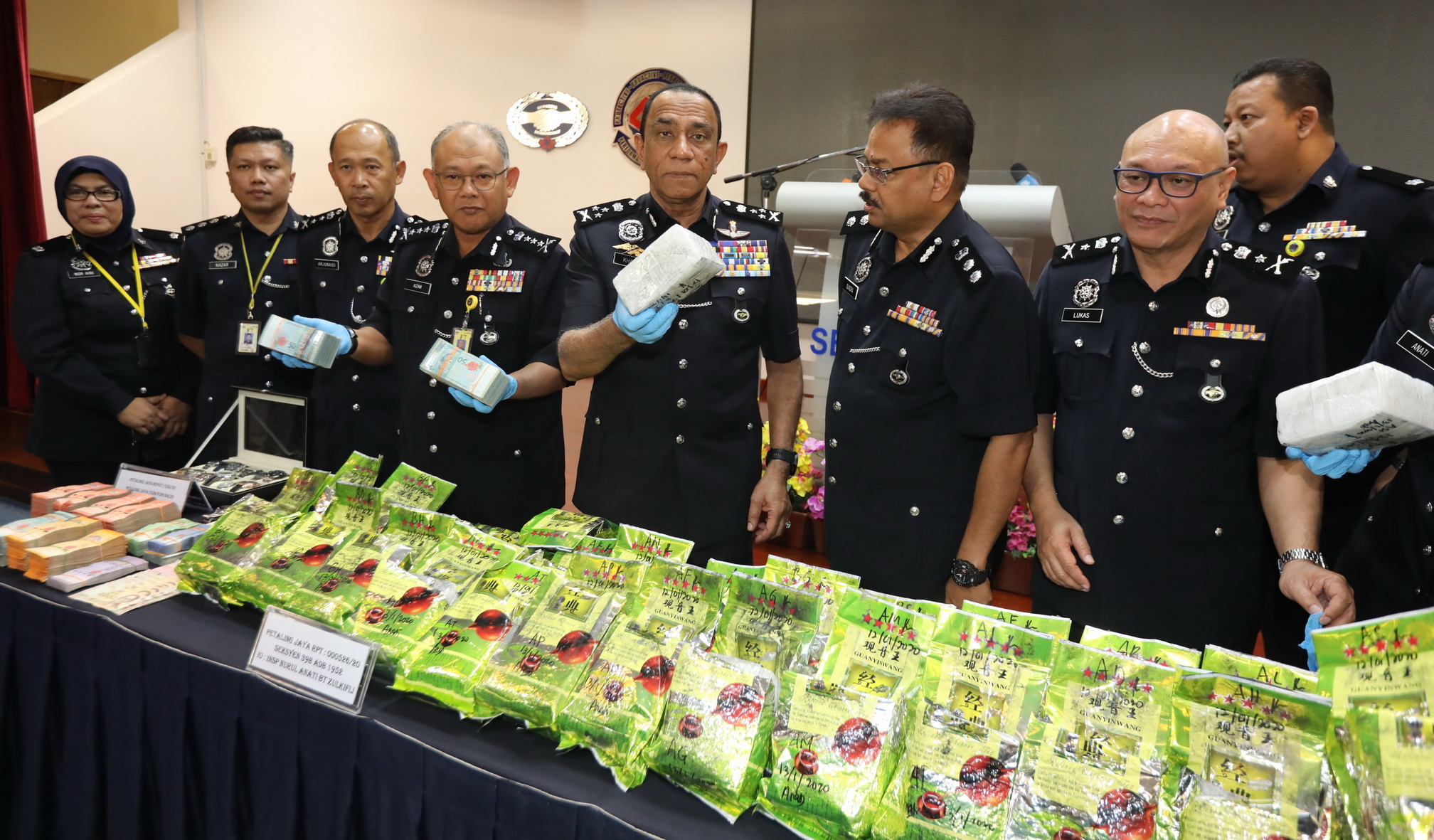 莫哈末卡利（左5）展示警方起获藏有冰毒的“中国茶叶”，左4为雪州总警长拿督诺阿占。