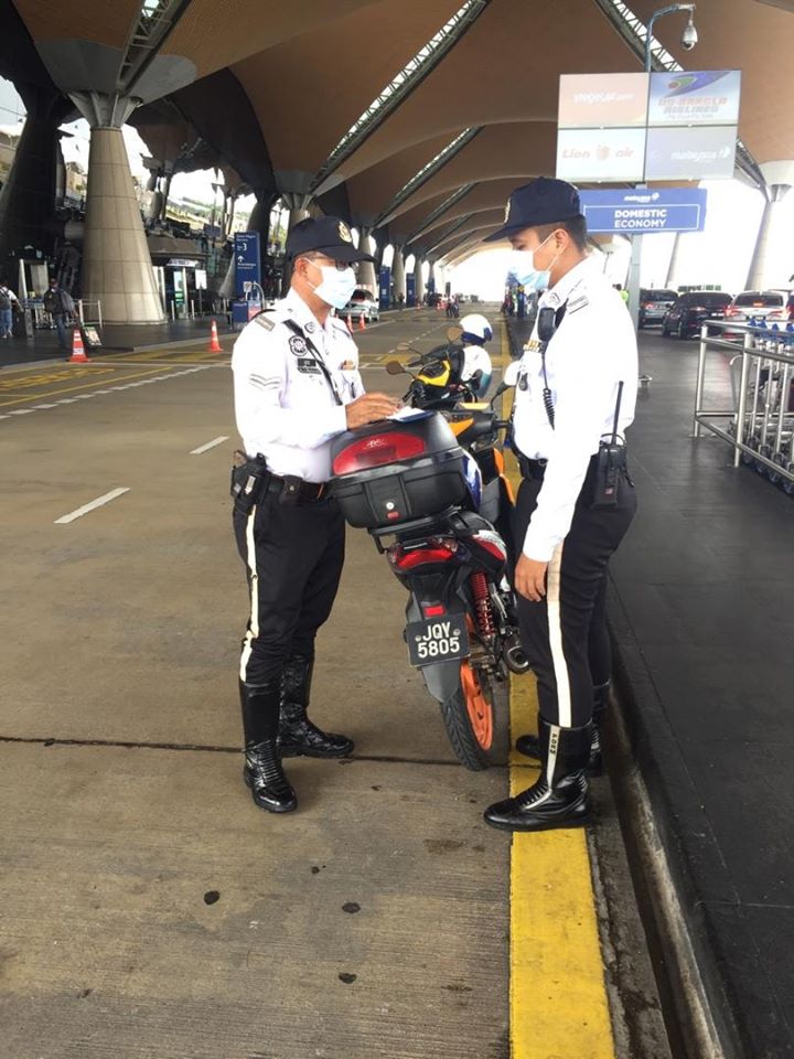 在机场值勤的交警，遵守指示戴上口罩。