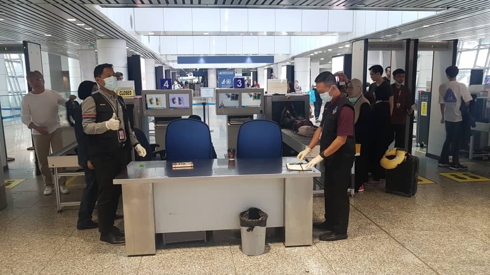 在机场检测关卡值勤的官员，也已戴口罩。