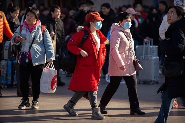 北京火车站外的旅客周一戴上口罩。