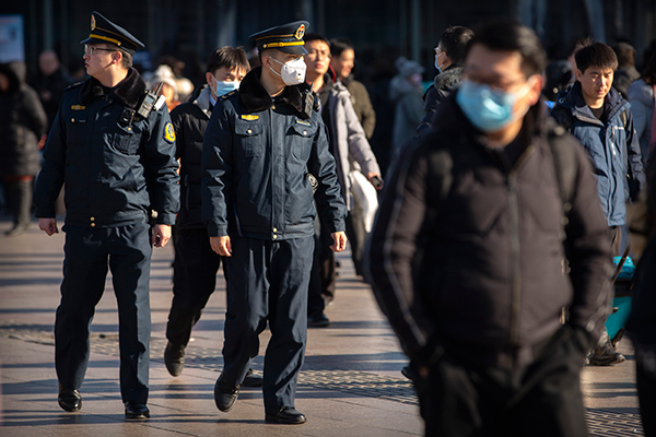 北京火车站外的执法人员，也戴上口罩。