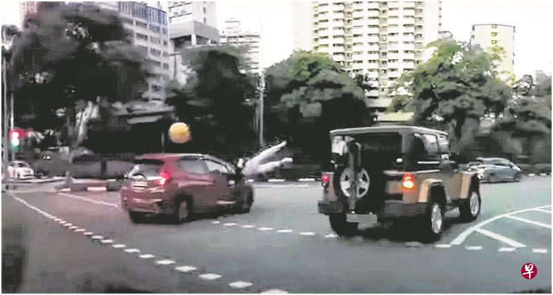 男学生在过马路时被一辆右转的红色车子撞飞。 