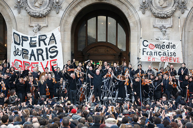 音乐家周六在巴黎歌剧院前为激进的抗议者，举行免费音乐会。（美联社）