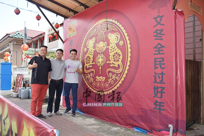 彭城葳（左）和两名来自吉隆坡的游客，在文化街新春布景前拍照。