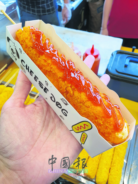 韩式芝士热狗棒炸到脆卜卜，内层夹香肠，表面洒上特制调味料，咬开有拉丝芝士，是韩国街头人气小食。
