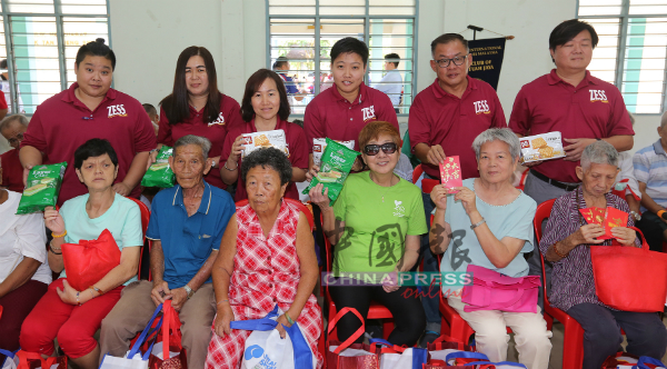 东方食品工业有限公司销售经理吴炜江（站者右2）率领团队，分发食品给老人。