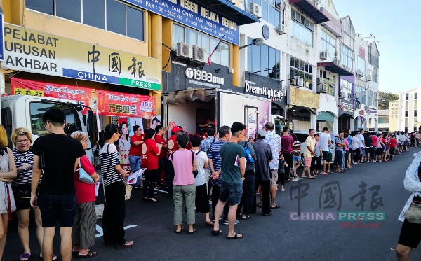 《中国报》甲州办事处出现长长人龙，排队等候换取饮料。