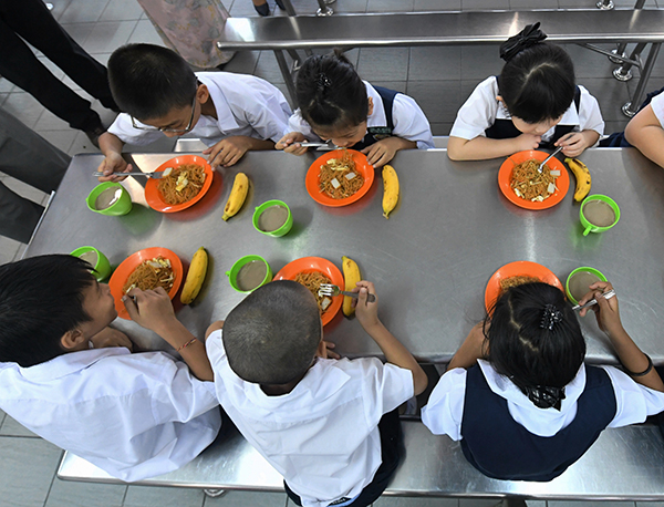 吉隆坡沙叻秀华小的学生一起享用营养早餐，首天吃的是炒米粉、香蕉及美禄。