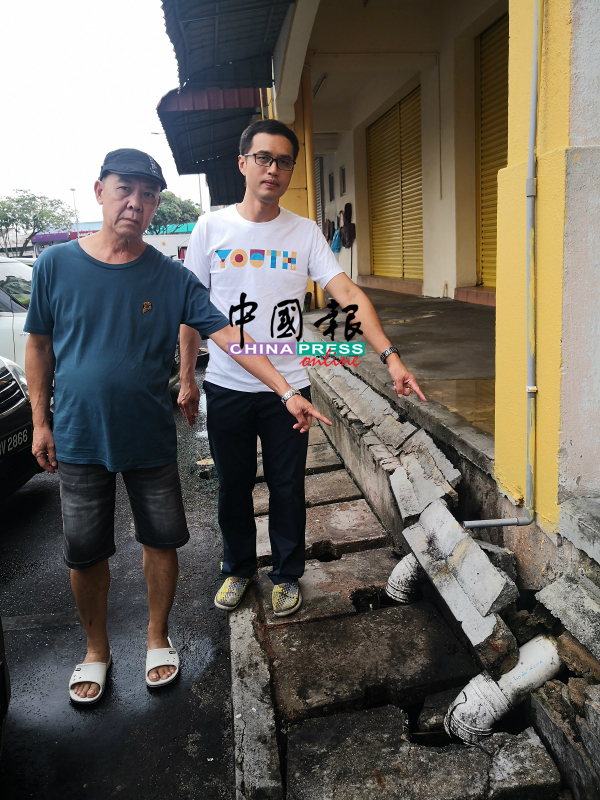 李名财（左）和李翰霖展示崩塌的沟壁。