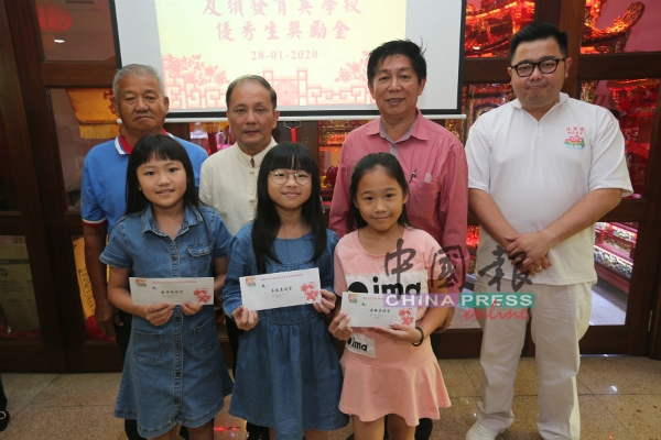 李传财（后排左2）联合朱伟胜（右起）、林谦典及吴亿成（左），颁发奖励金给育英小学学生。