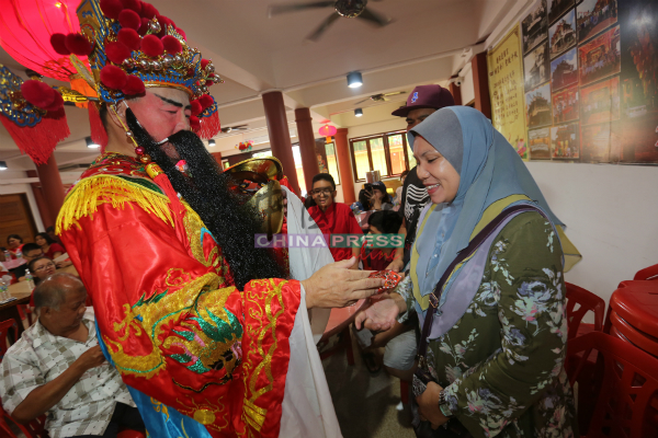 财神爷分发红包给马来同胞的学生家长。