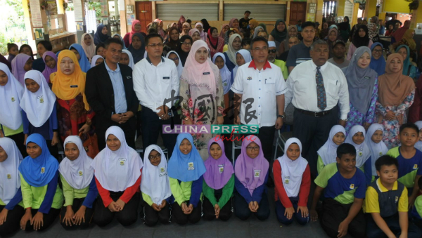 阿德里（右4）与出席武吉峇汝国小学生援助金的嘉宾及学生。