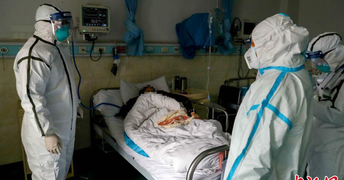 穿着防护服的医护人员，周一在武警湖北省总队医院隔离区探望病人。