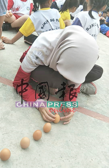 巫裔学生也进行“立春”活动，将鸡蛋立起来。