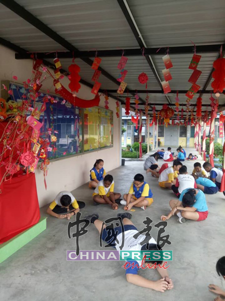 学生们在布置红彤彤充满新春气息的校园进行立春活动。
