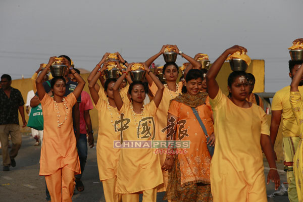 一众女信徒背负着牛奶，参与游行。
