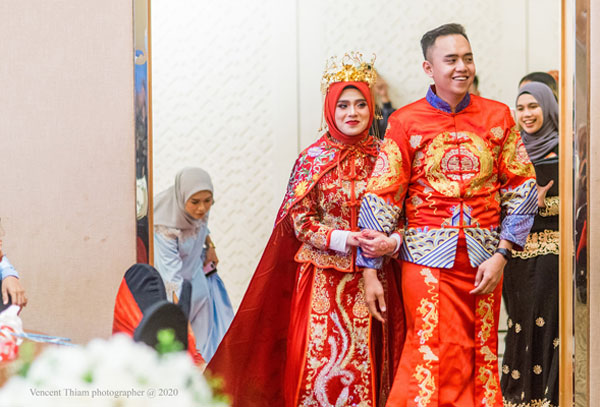 巫裔新人穿龙凤褂步入婚礼现场。
