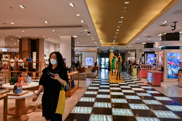 一名戴上口罩的妇女28日在曼谷的一家百货商店中行走。