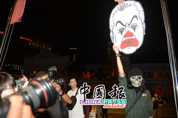 民众高举与慕尤丁相似的表情纸模板，以示抗议。