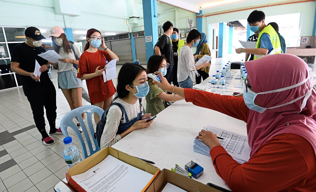 马大第十宿舍的中国留学生在宿舍诊所测量体温。