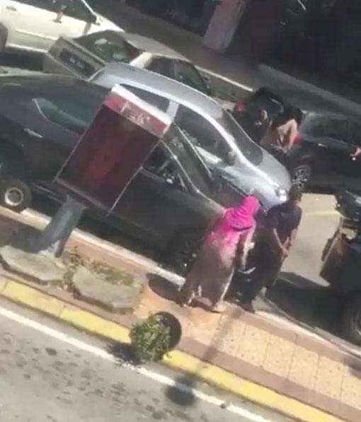该名妇女不满轿车被拖走，动手捶打执法人员及前来劝架的民众。