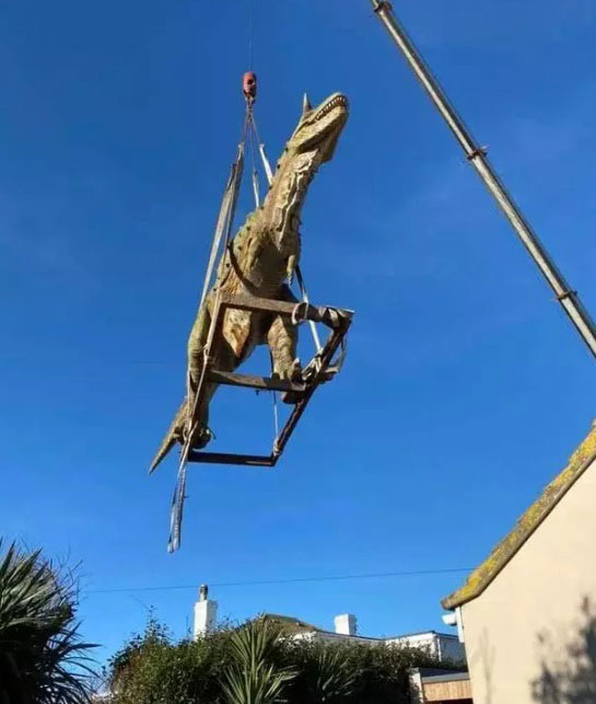 专业的运输吊起长达5公尺的恐龙雕像。