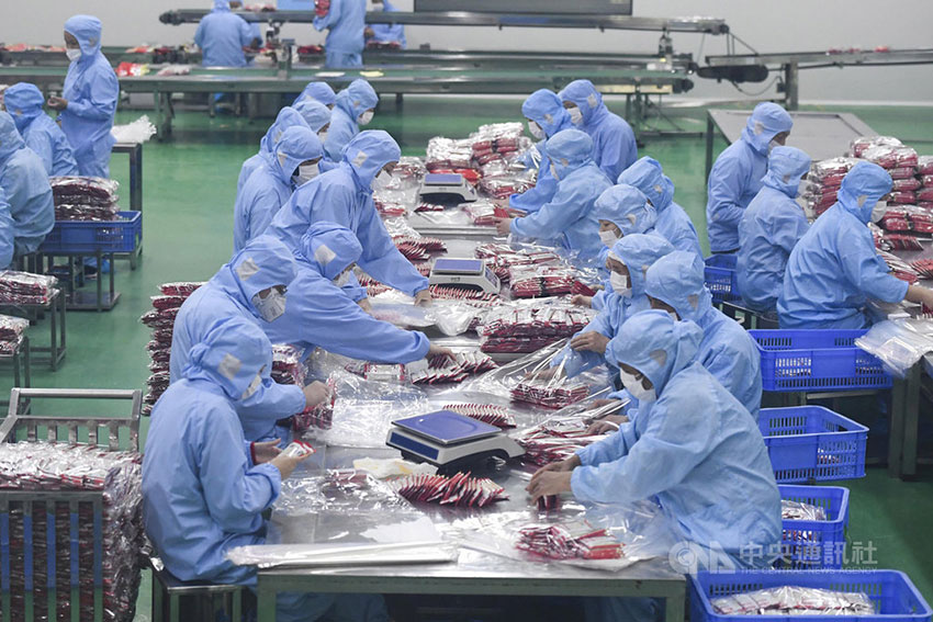湖南食品公司员工采取防疫措施后，入厂包装产品。（中新网）