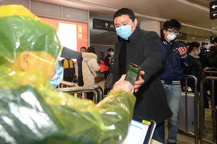 在杭州东站，从贵州乘坐专列抵达杭州的复工人员，出站时出示申领的杭州健康码，并核验个人信息。（新华社）