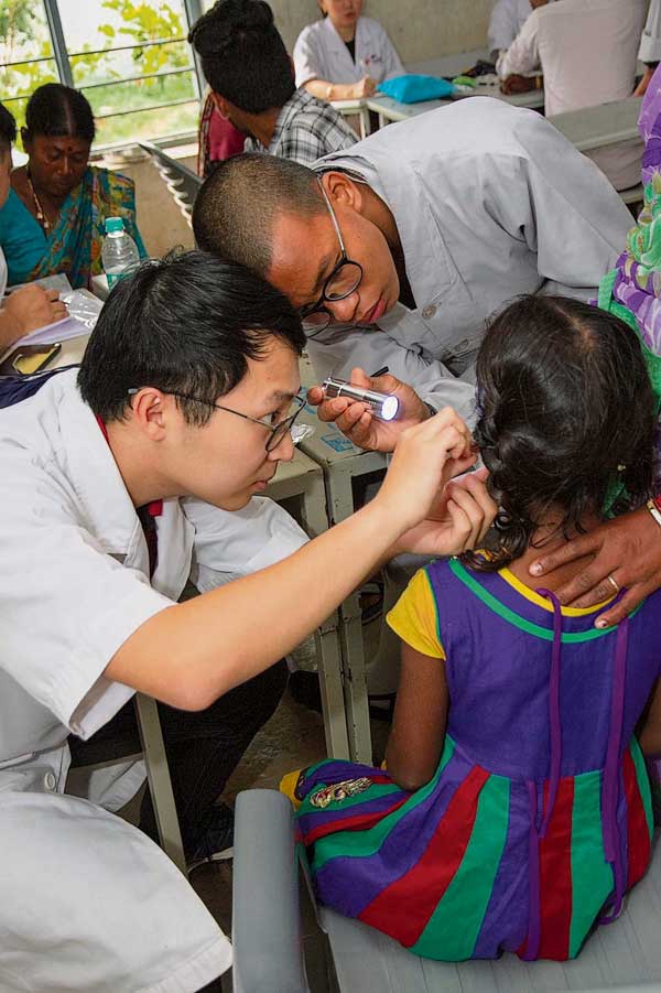 英迪传统中医师队伍在印度沙德纳加尔区域义诊，小心翼翼为一名孩童做检查。