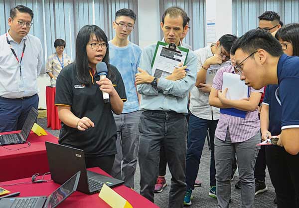 “以指模为基础的点名系统”创作者林俊延（左）和陈美淇（右），正向评审讲解作品概念。