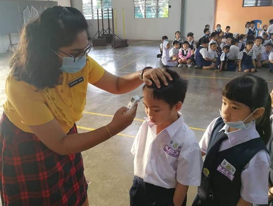 老师逐一为学生探测体温，确保防疫措施万无一失。　