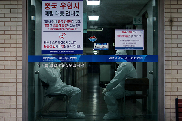 韩国大邱一所医院的入口处，身穿防护服的医护人员在随时待命，准备接收新患者入院。（法新社）