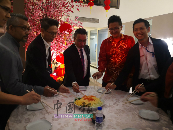 阿德里（左3）与公司高层及嘉宾一起捞生，欢庆新年。右起陈桂鑫、谢守钦、汤洳升。