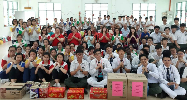 学生到访武吉峇汝老人院献爱心，坐椅子者左4为江雪霞。（档案照）