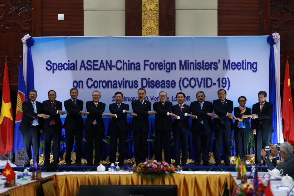 周四在寮国永珍，中国国务委员兼外长王毅（左6）和东协10国外长以东协方式手拉手。（新华社）