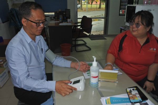 刘志良（左）自行检查血压。