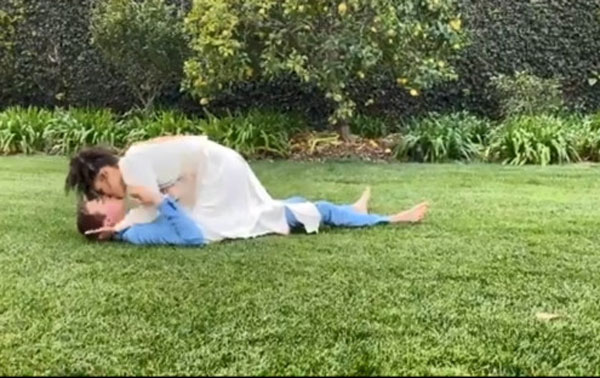 幸福的两人当众躺在草地上忘情激吻。