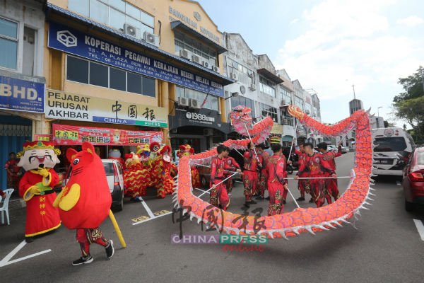冠军龙在《中国报》马六甲办事处门前表演。