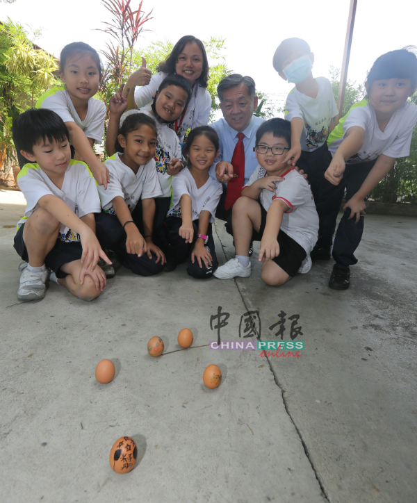 培二小学生与师长挑战立蛋成功。