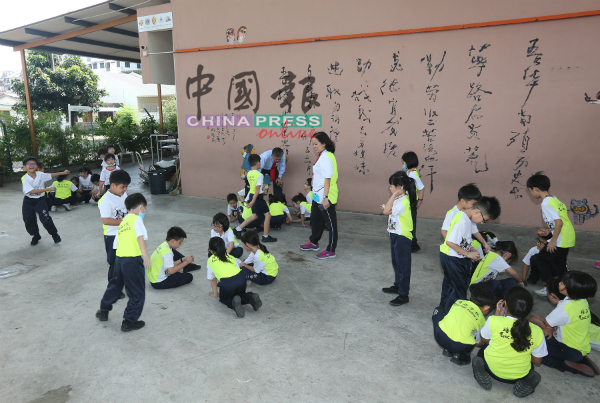 培二小学学生在课室外参与立蛋游戏。