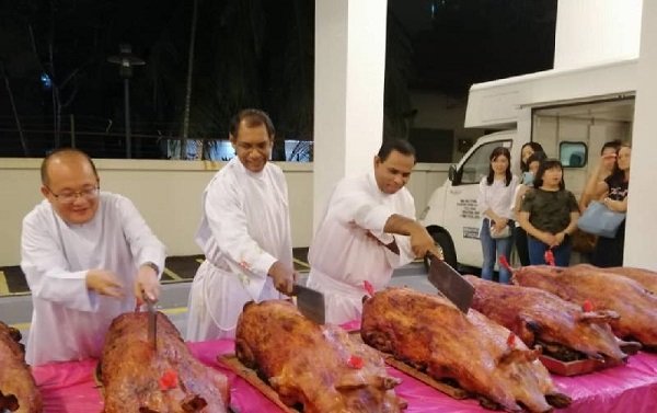年初八晚，天主教徒切烧猪庆祝福建人新年。（档案照）