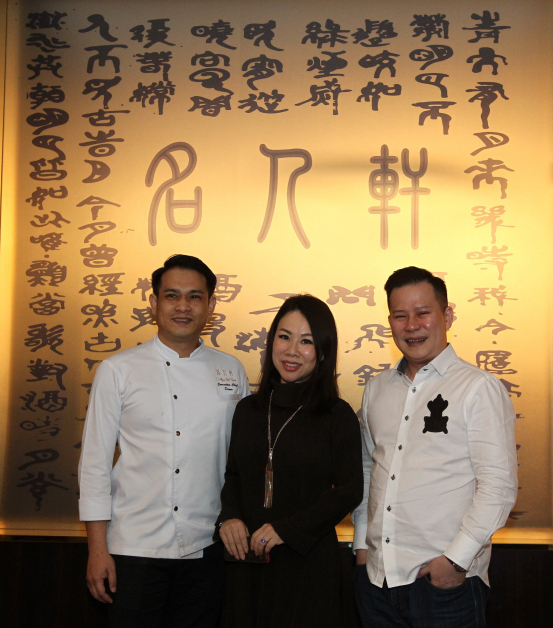 “名人轩”总厨赖国胜（左）来自东马，拥有23年任厨经验，擅长创意粤菜料理。中为餐厅股东拿督王碧兰和拿督斯里洪志勇合摄。
